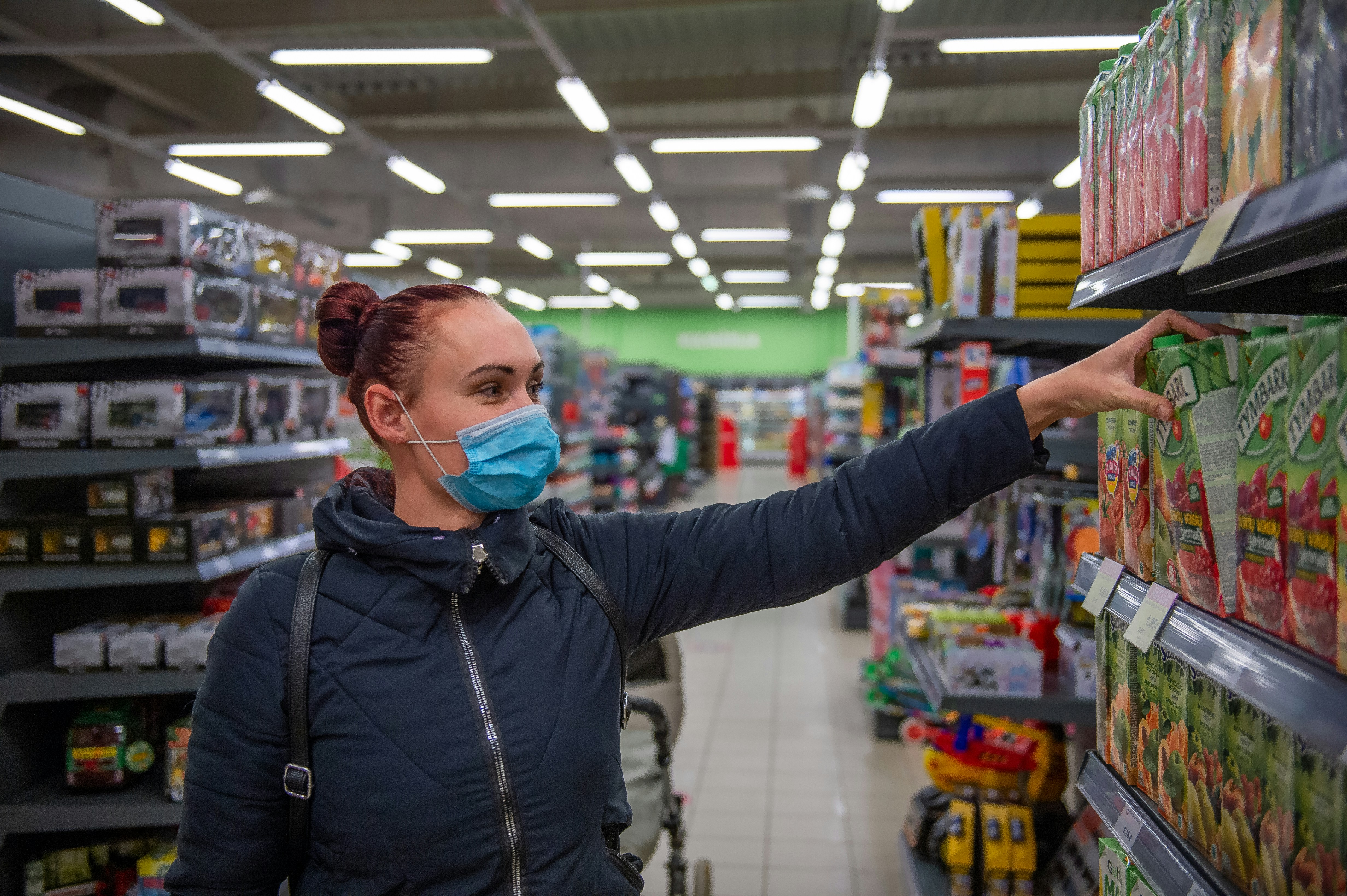 Retail worker in supermarket wearing a facemask 