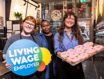 Tantrum doughnuts employees with doughnuts and living wage logo