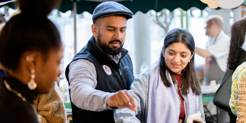 People at borough market eating food from stall