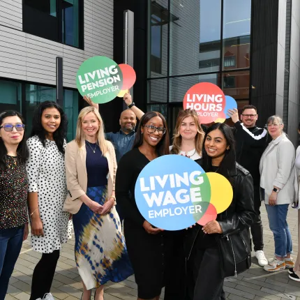 West Brom group of employees with Living Wage, Living Hours and Living Pensions logo props
