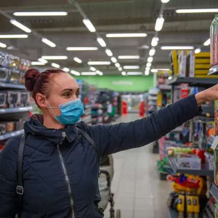 Retail worker in supermarket wearing a facemask 
